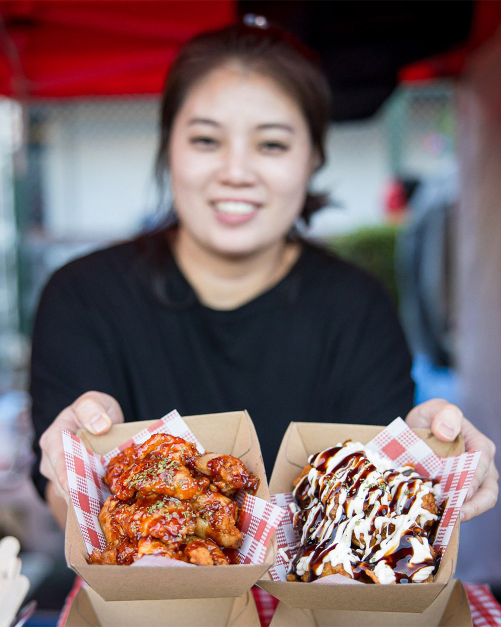 a person holding out street food in boxes