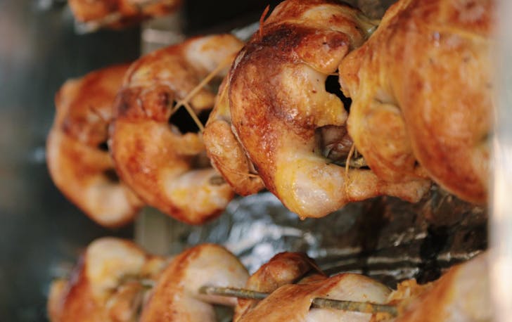 Line of perfectly roasted rotisserie chicken.