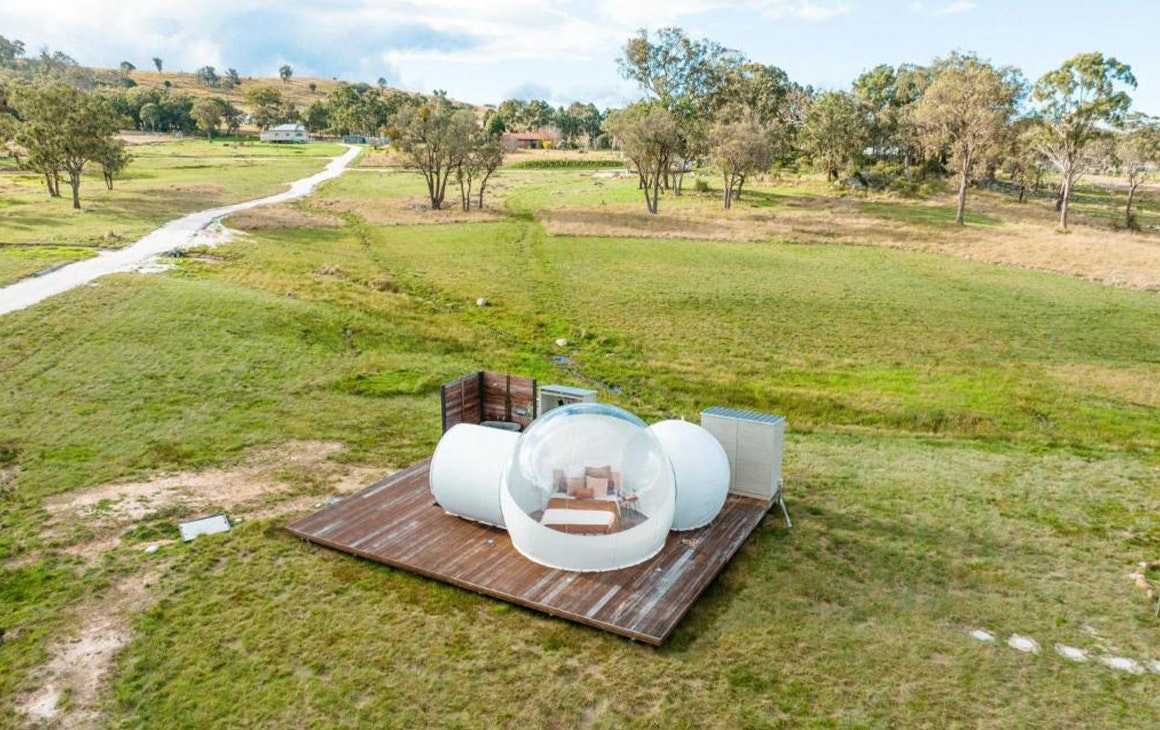a bubble tent surrounded by countryside