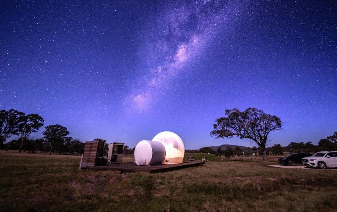 the bubble tent lit up under a starry sky