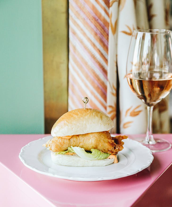 a crisp bug roll on a plate with a glass of wine
