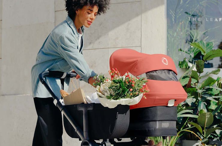A mother pushing her baby and groceries in the new Bugaboo Donkey 5 pram. 