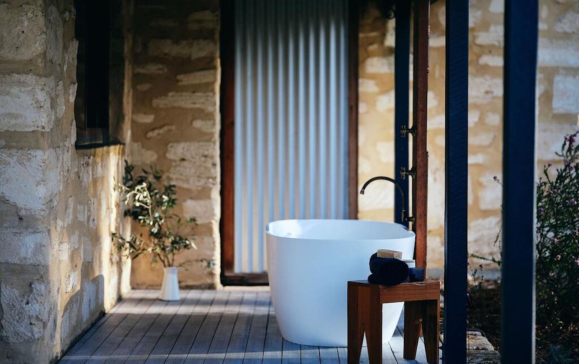 an outdoor stone bath on a wooden deck