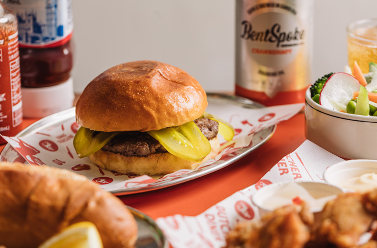 A diner with bottles of sauce and a burger, a best cheap eats Melbourne spot. 