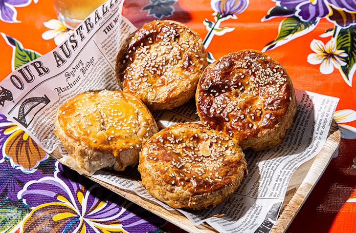 four pies on a serving tray lined with newspaper.