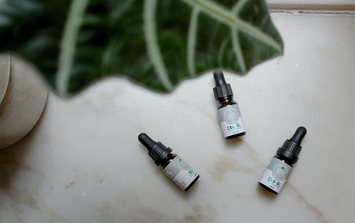 three bottles of cbd oil on a bench