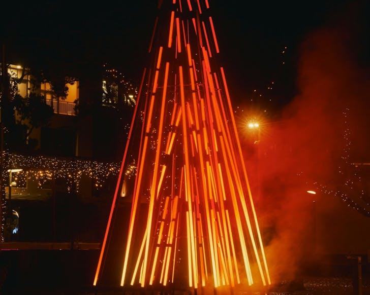 Angus Muir's hero light installation for By the Fire: a sculptural bonfire animated by ambient light, drifting smoke, and the soothing sounds of a crackling fire, surrounded by log seating