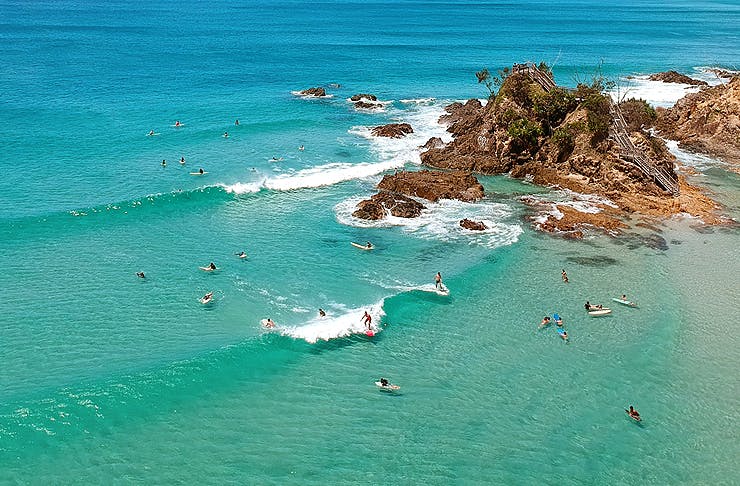 Bird's eye view over a turquoise waves and sandy beach. 