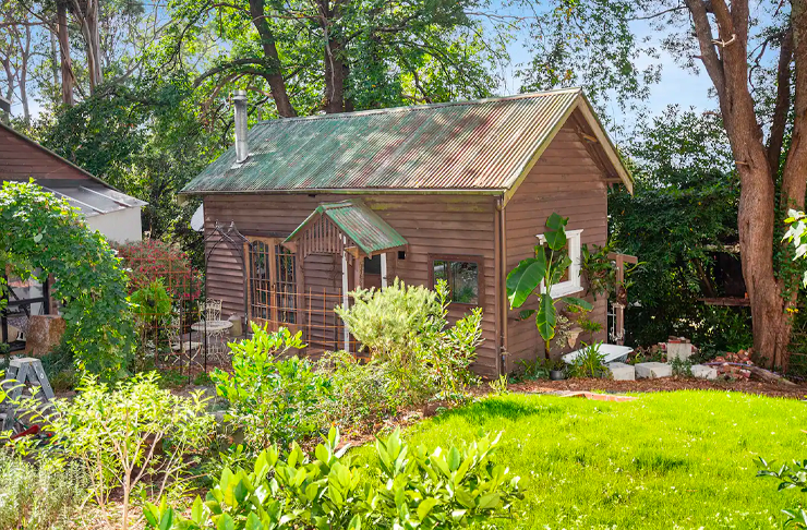 A rustic cabin positioned between gumtrees, considered one of Victoria's best Airbnb cabin stays. 