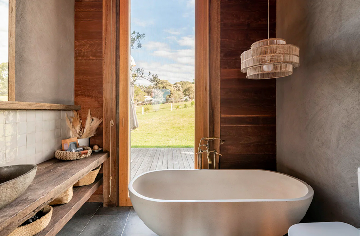 A bathtub overlooking hills in one the best cabin stays in Victoria.