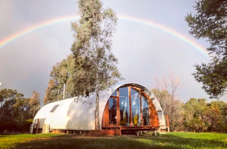 a domed cottage in the countryside with a rainbow overhead. One of Victoria's best cabin airbnbs.