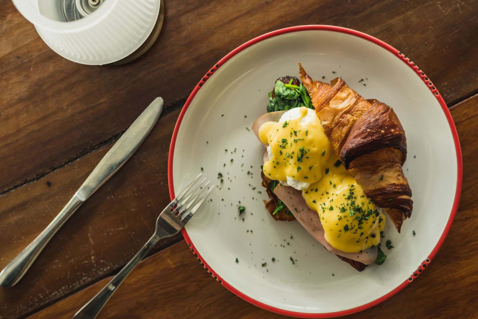 a plate of eggs benny on a croissant