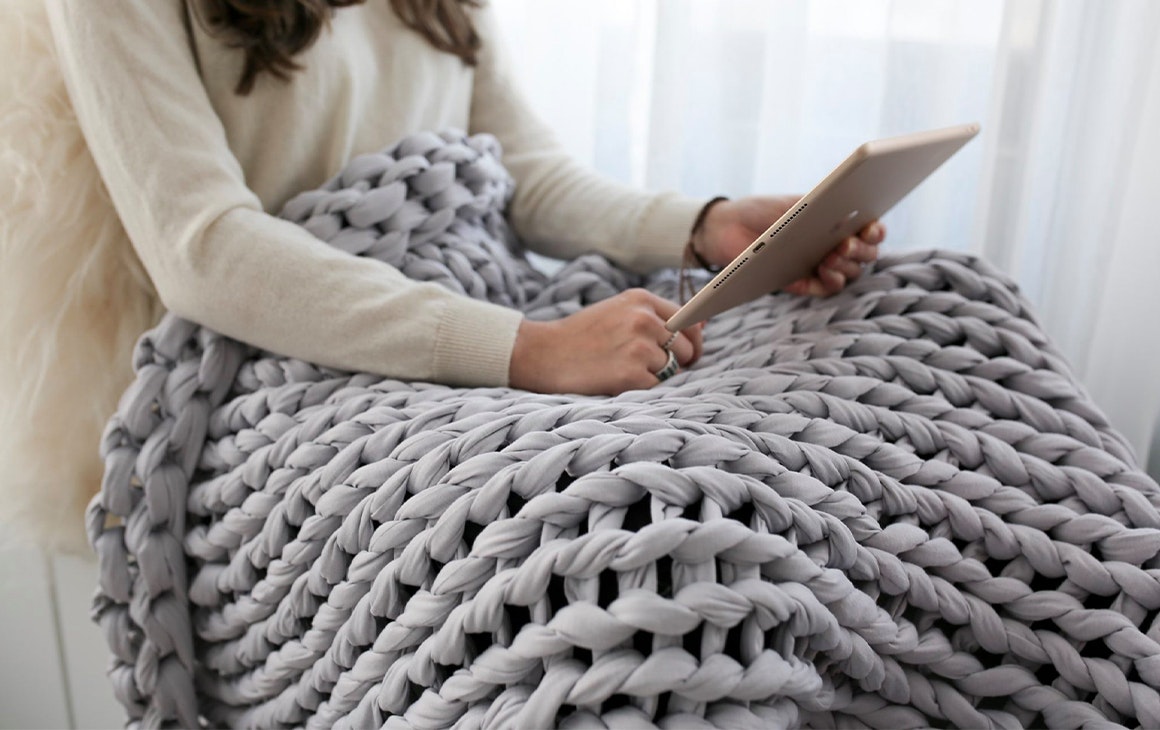 a woman under a woven blanket