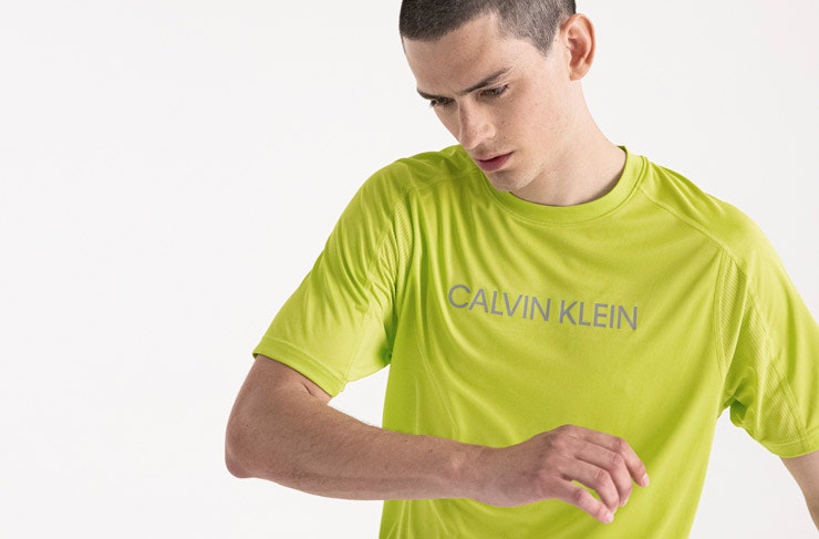A model wearing a lime geen t-shirt from Calvin Klein