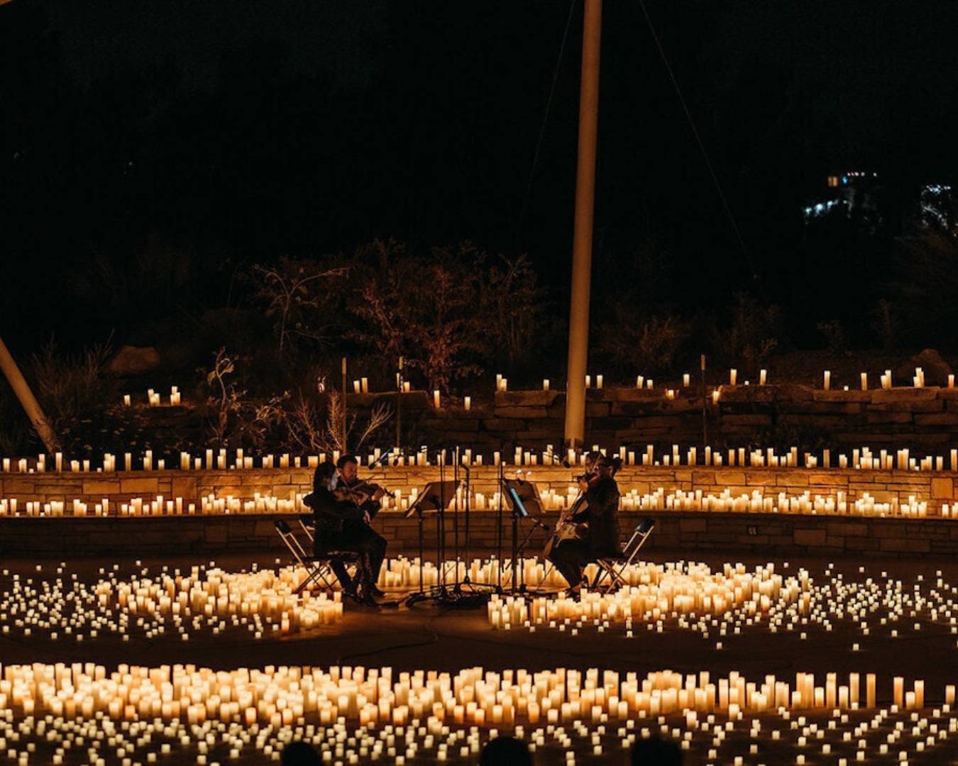 violinists playing surrounded by candles at a brisbane date idea