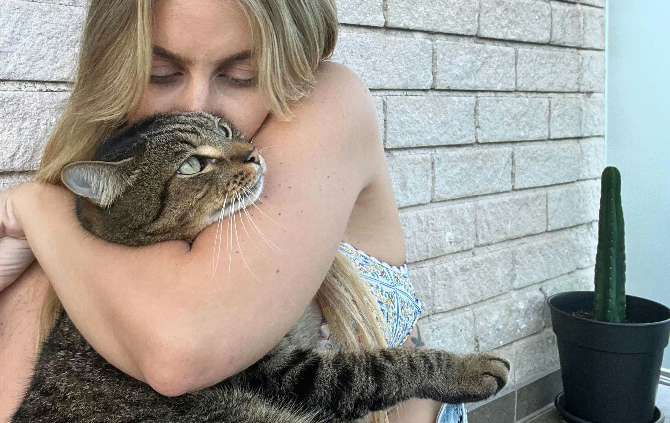 Woman hugs and kisses her cat
