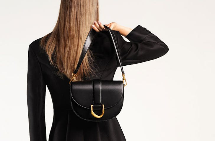 A woman facing away from the camera holding the Gabine bag over her shoulder