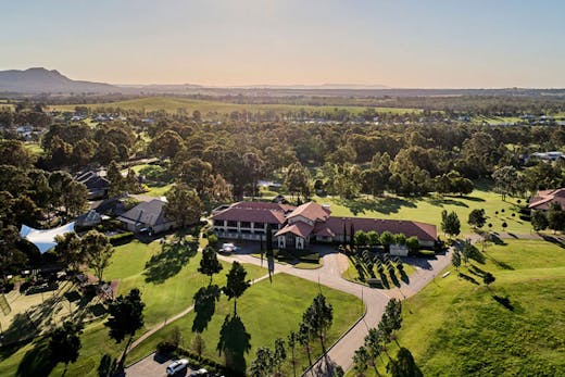 An aerial view of the Chateau Elan resort in the Hunter Valley, surrounded by vineyards and its golf course.