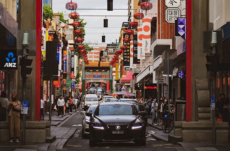 A car driving down little Bourke St. 