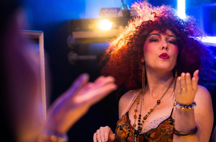 A Chicago The Musical cast member, all dolled up, and blows a kiss to the mirrors.