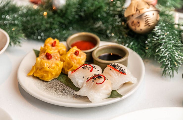 Dumplings served on a white plate with Christmas decorations. 