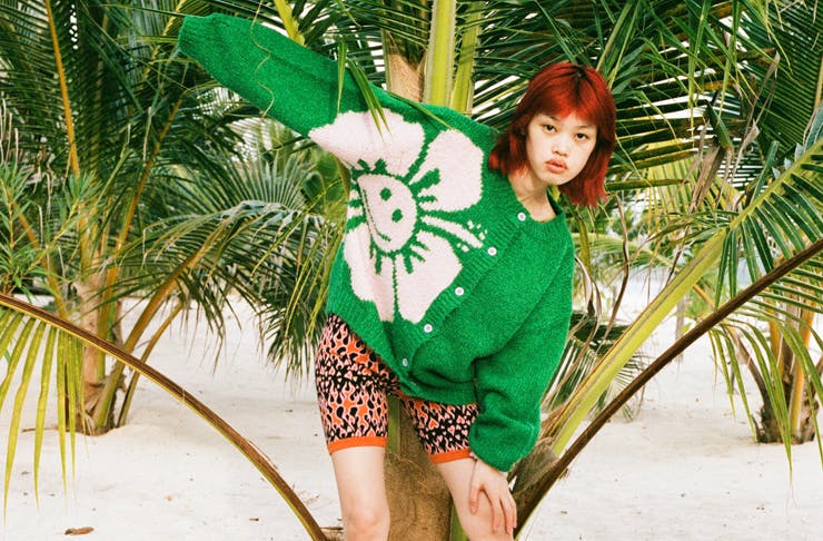 A model wearing a bright green chunky knit sweater. 