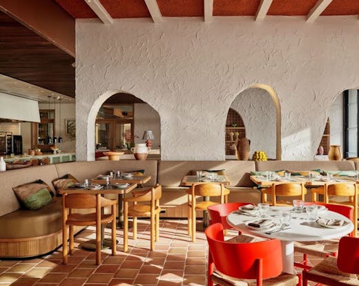 Cibaria's interior dining area during the day with booth seating on the left and a dining table on the right. 