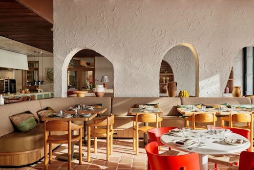 Cibaria's interior dining area during the day with booth seating on the left and a dining table on the right.