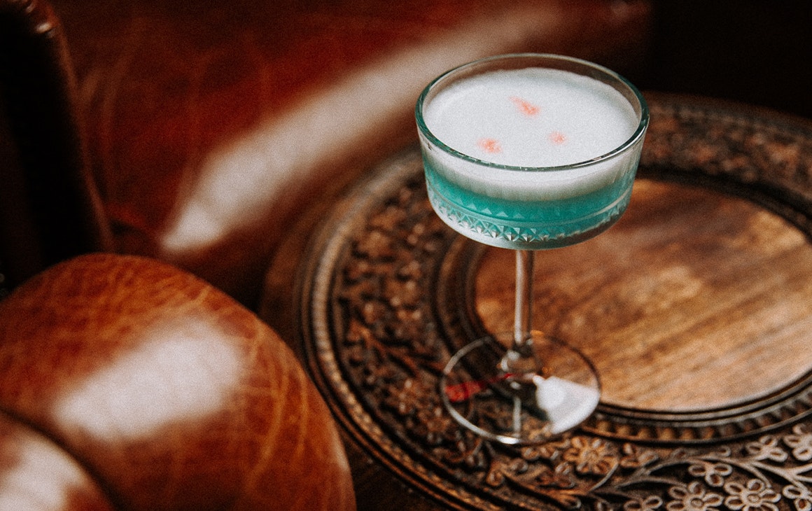 a blue cocktail on a table