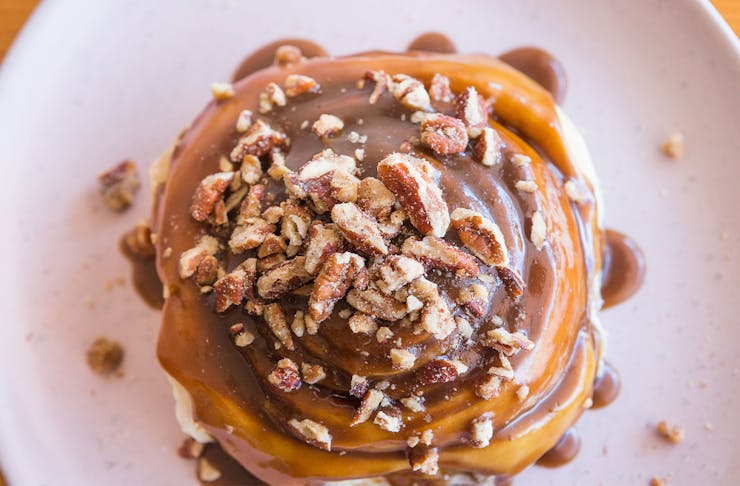a cinnamon scroll drizzled in caramel sauce