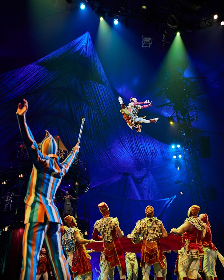 A acrobat flies through the air at Cirque Du Soleil