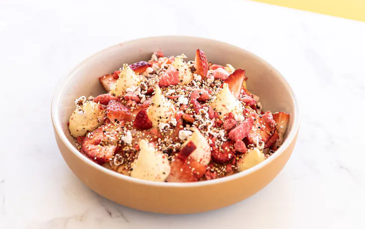a dish topped with strawberries and cream