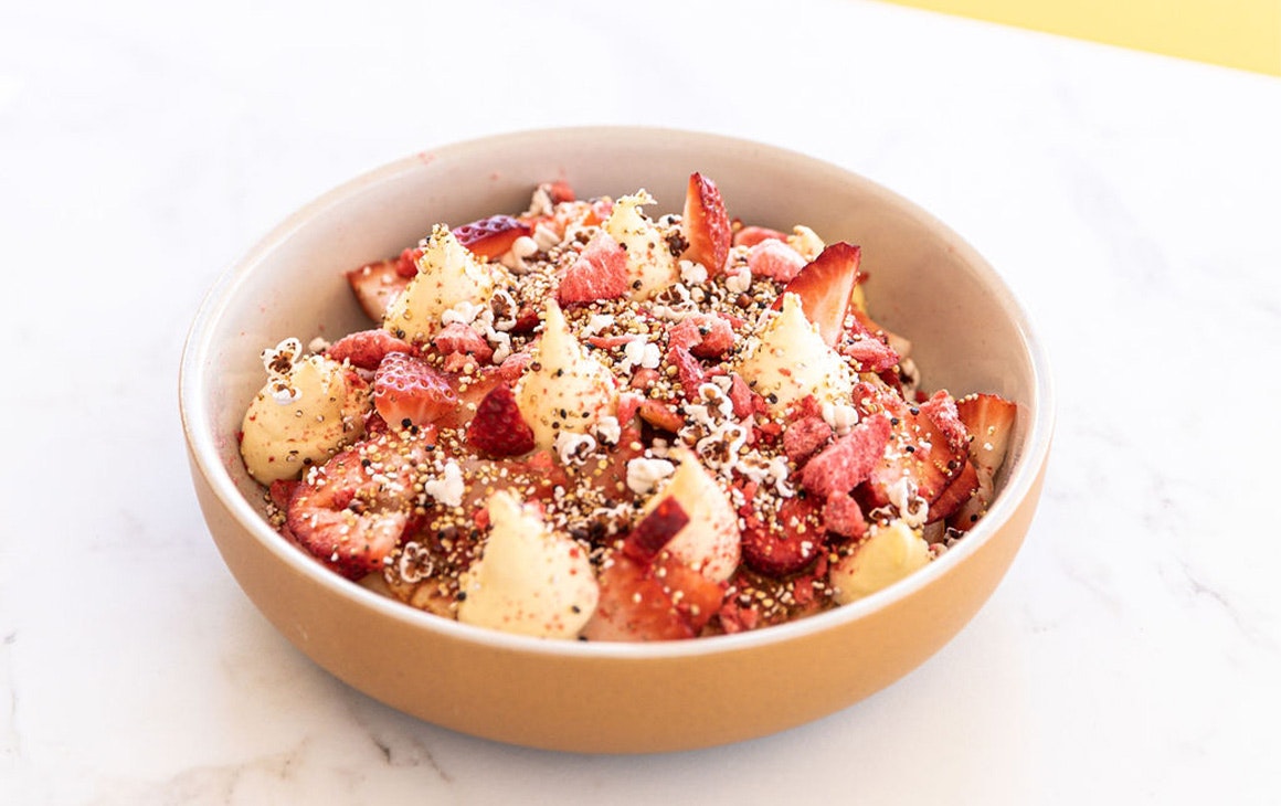 a dish topped with strawberries and cream