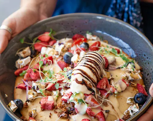 a hotcake piled with berries and gelato