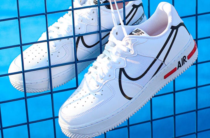 A pair of white Nike Air Max against a blue background. 