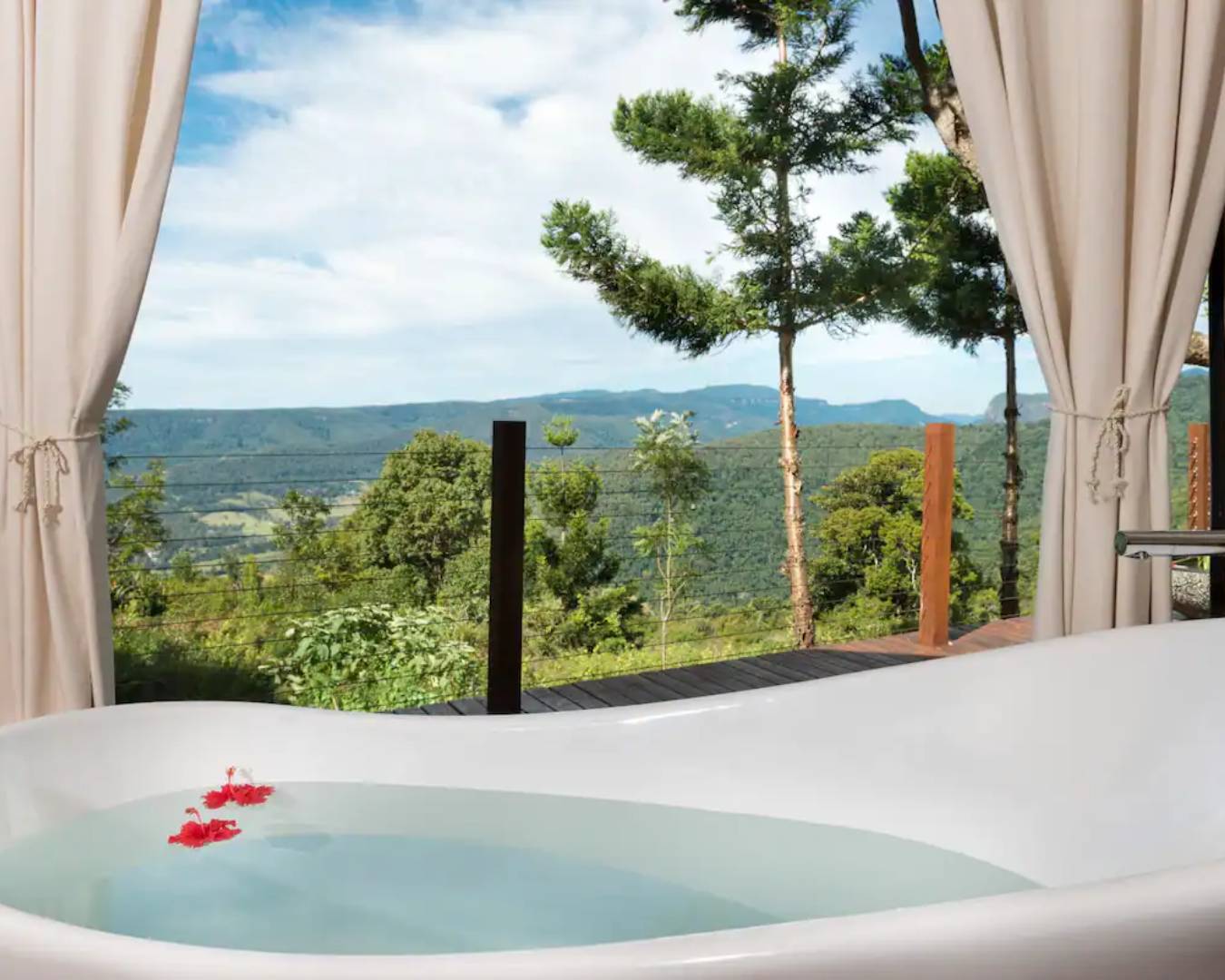 bathtub overlooking view of green valley 