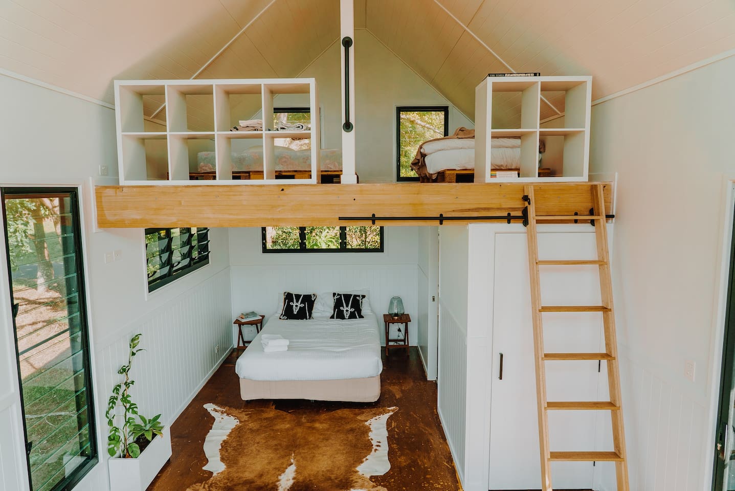looking into a bedroom with a loft area over the bed