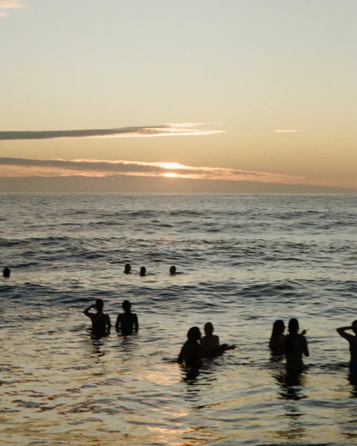 A group of people swimming at Coogee Beach at sunrise