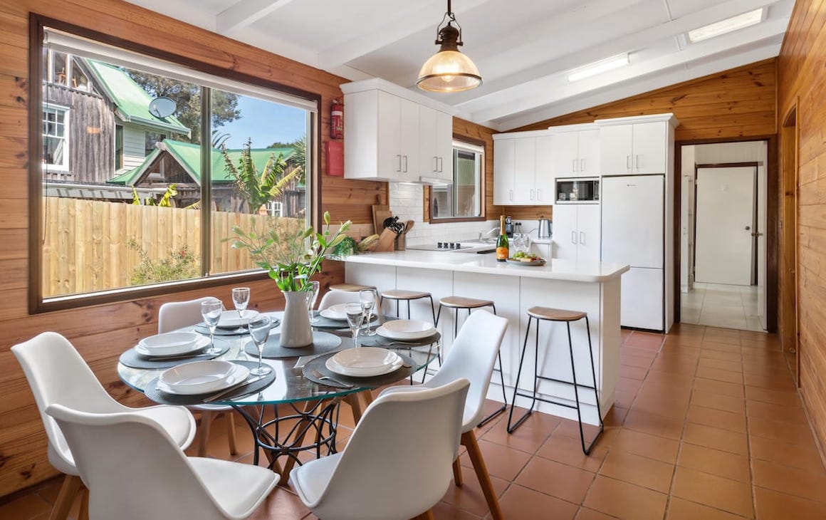 a kitchen and dining space with timber walls