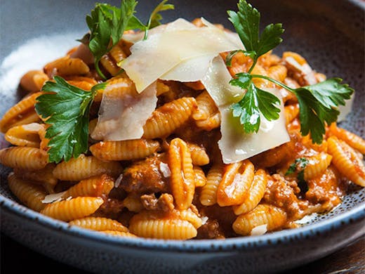 a bowl of shell pasta with bolognaise sauce