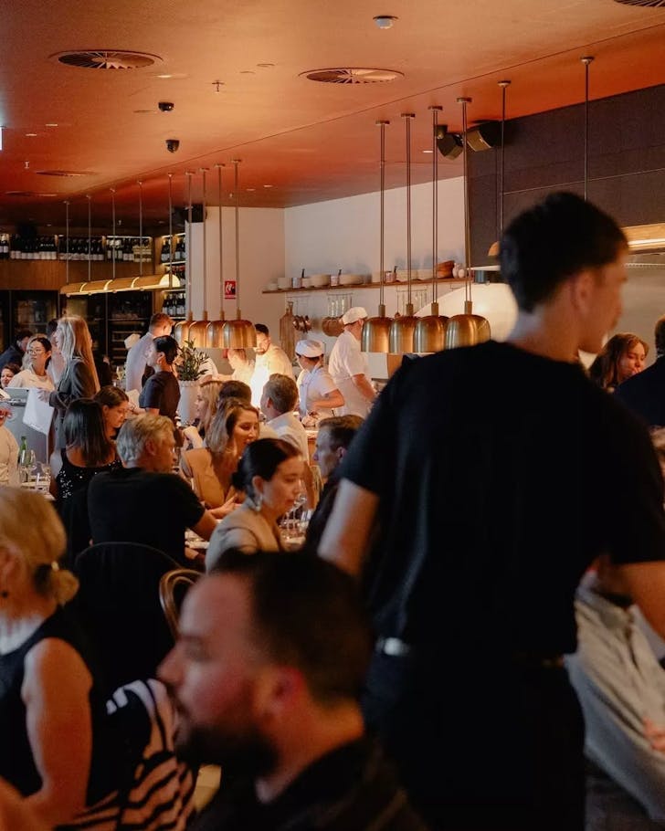 A busy restaurant with staff moving in between tables