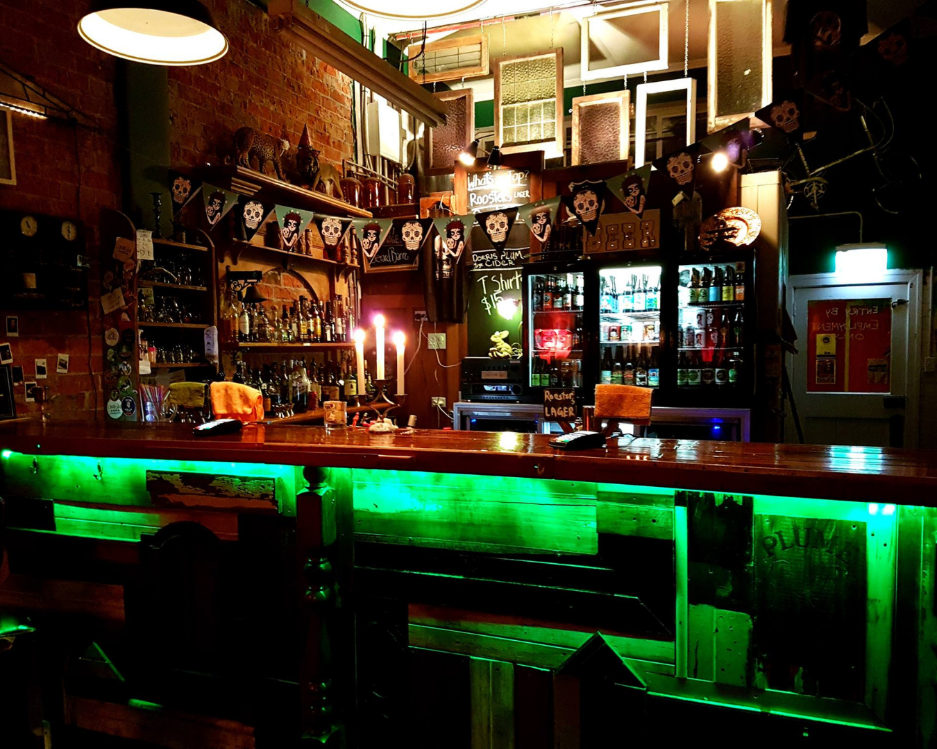 A dimly lit bar with neon lighting under the bar counters