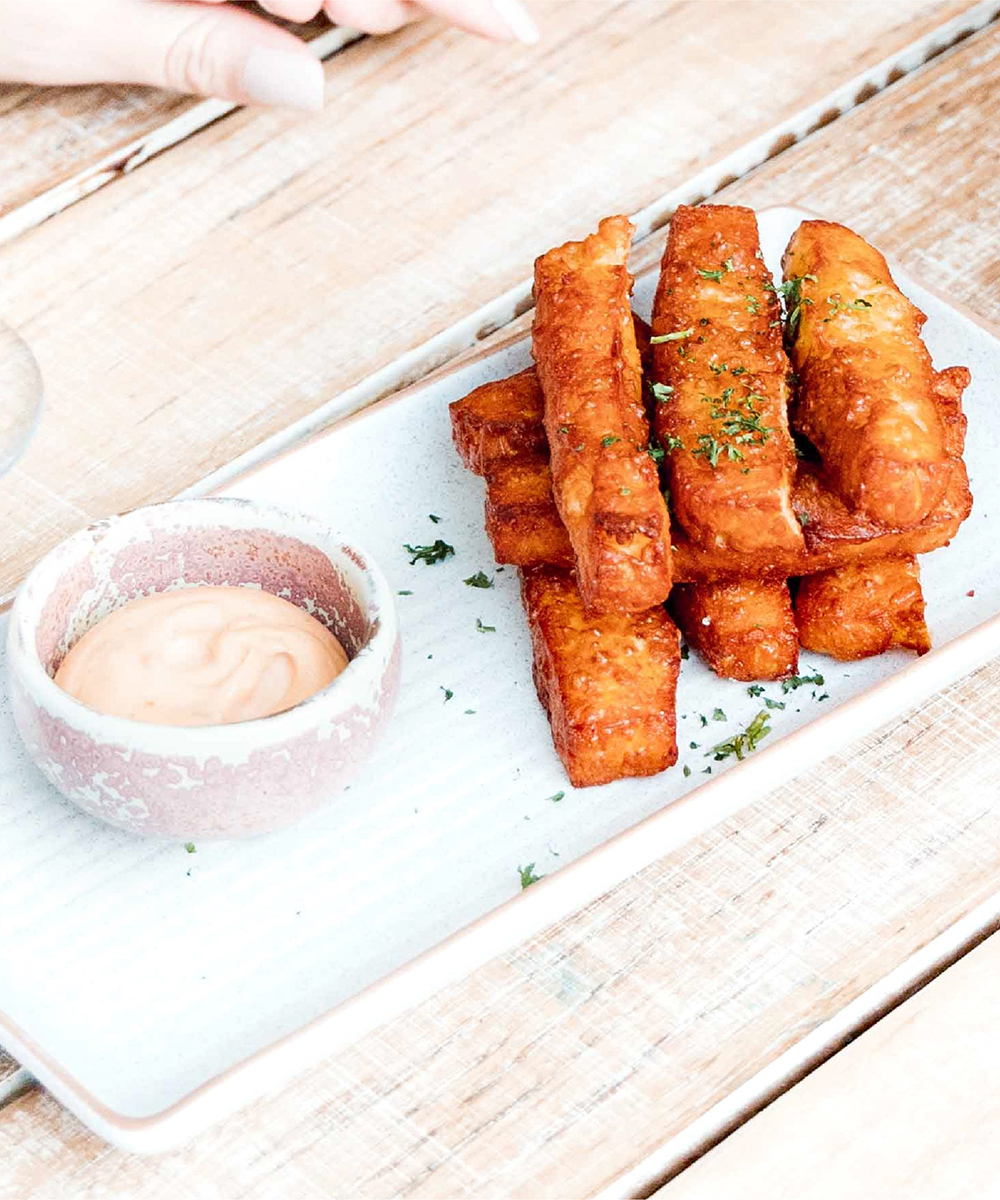 a plate of haloumi chips and dipping sauce