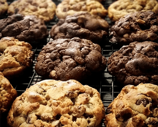 A row of large cookies fresh from the oven.