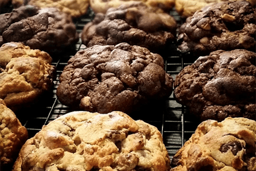 A row of large cookies fresh from the oven.