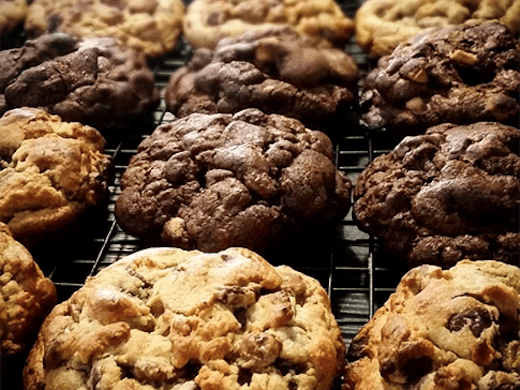 A row of large cookies fresh from the oven.