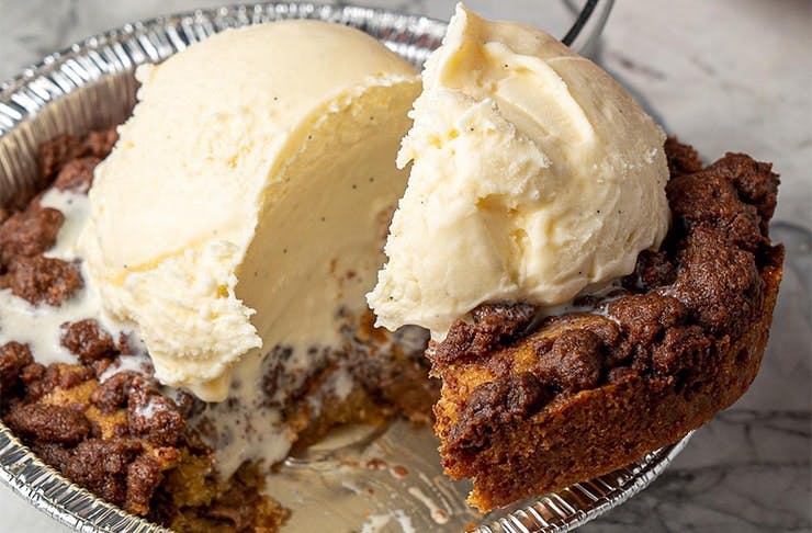 A single serve cookie pie topped with a scoop of gelato