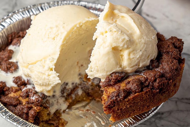 a spoon scooping into a small cookie pie with gelato