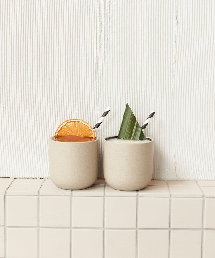 two ceramic cups side by side filled with frozen cocktails
