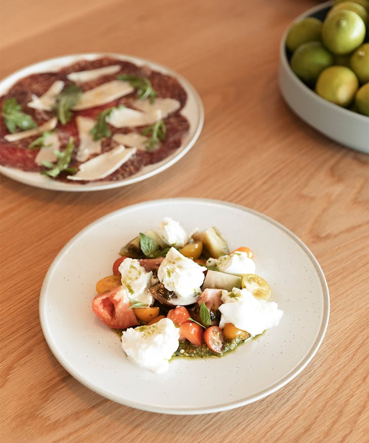 a plate of mazzarella salad and breasola